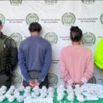 Se observan dos personas capturadas de espaldas. A cada costado  funcionarios de Policía nacional.  Atrás un pendón de Policía        Nacional