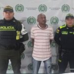 En la imagen se ve una persona detenida, entre dos uniformados de la Policía.