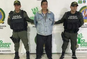 En la fotografía aparece el capturado junto a dos agentes del Gaula de la Policía.  En la parte superior está un banner de la Policía Nacional