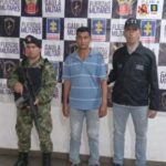 En la fotografía aparece un hombre capturado, acompañado de un servidor del CTI y un uniformado del Ejército Nacional.  En la parte posterior un banner con logos de la entidad.