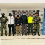 En la fotografía aparecen los tres capturados junto a un servidor del CTI, un agente de la Policía Nacional y tres soldados del Ejército Nacional. En la parte superior están un banner de la Fiscalía General, un banner de las Fuerzas Militares y un banner de la Policía Nacional.