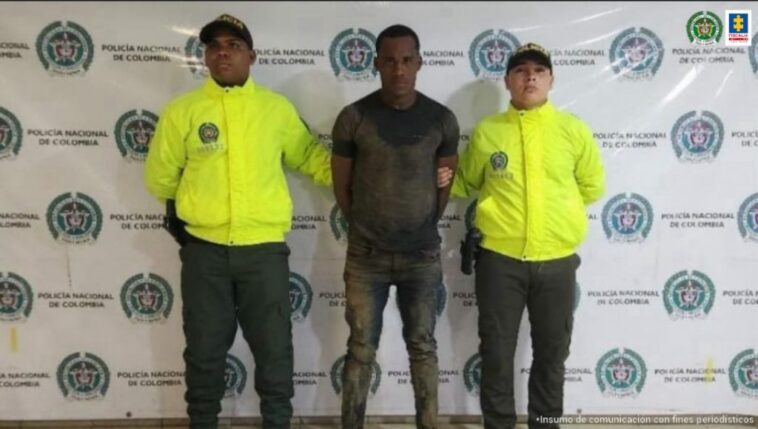 En la fotografía aparece el capturad junto a dos agentes de la Policía Nacional. En la parte superior está un banner de la Policía Nacional