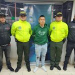 En la fotografía aparece el capturado junto a dos servidores del CTI y dos agentes de la Policía Nacional. En la parte superior está un banner de la Policía Nacional