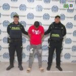 En la fotografía aparece una persona capturada, acompañado de dos uniformados de La Policía. En la parte posterior un banner con logos de la entidad.