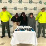 En la fotografía aparecen las capturadas junto a dos agentes de la Policía Nacional. En la parte posterior está una mesa 23 teléfonos celulares recuperados