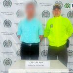 En la fotografía aparece el capturado junto a dos agentes de la Policía Nacional.  En la parte superior está un banner de la Policía Nacional