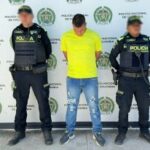 Dos uniformados de la Policía Nacional custodian al procesado tras su captura en flagrancia.