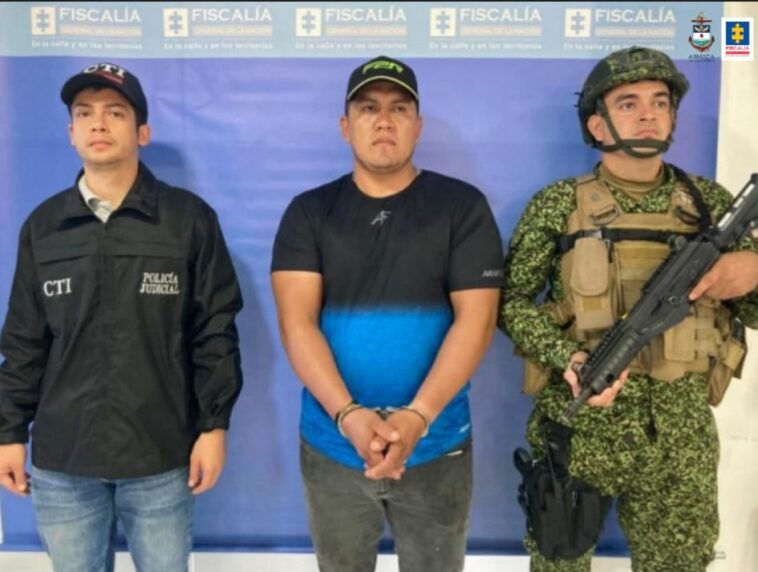 En la fotografía aparece el capturado junto a un servidor del CTI y un infante de marina. En la parte superior está un banner de la Policía Nacional