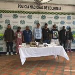 se observan los detenidos de frente en fila y a cada costado funcionarios de la Policía Nacional.  Atrás un pendón de Policía Nacional