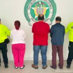 En la foto aparecen, de espaldas, dos hombres y una mujer en medio de dos uniformados de la policìa.