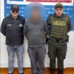 En la fotografía aparece el capturado junto a un servidor del CTI y un agente de la Policía Nacional. En la parte superior está un banner de la Fiscalía General de la Nación