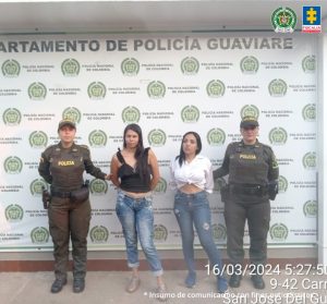 capturdasa de frente custodiadas por dos policías. Detrás banner de la Policía Nacional.