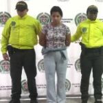 En la fotografía está Luisa Fernanda Lopera Flórez, mujer condenada por homicidio de un extranjero, con dos servidores de la Policía Nacional