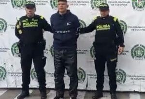 En la fotografía aparece el capturado junto a dos agentes de la Policía Nacional. En la parte superior está un banner de la Policía Nacional