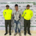 En la imagen aparece una persona con capucha entre dos policías uniformados.