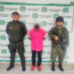 El imputado es esposado y detenido por dos uniformados de la Policía Nacional.  Detrás de él hay apoyo de la policía.