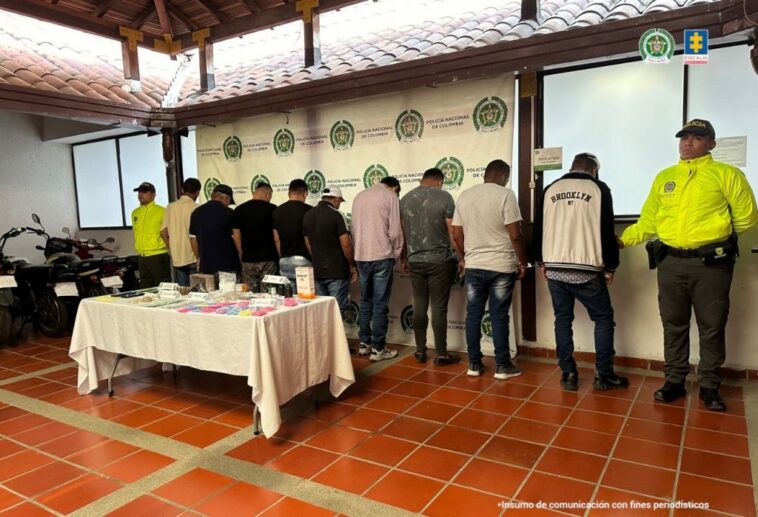 Descripción de foto: en la foto se aprecia a los capturados de espaldas siendo custodiados por miembros de la Policía Nacional.