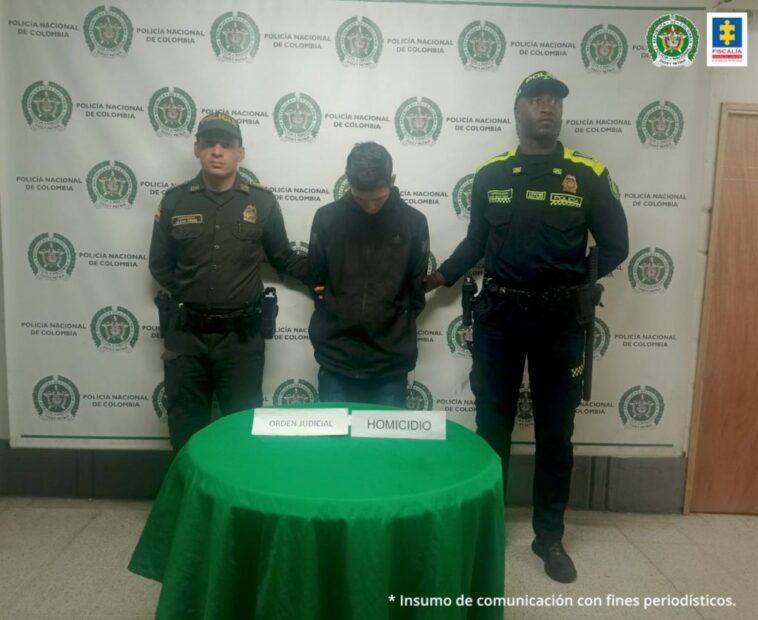 En la fotografía está el condenado con dos servidores de la Policía nacional q los lados. La foto fue tomada al momento de su captura.