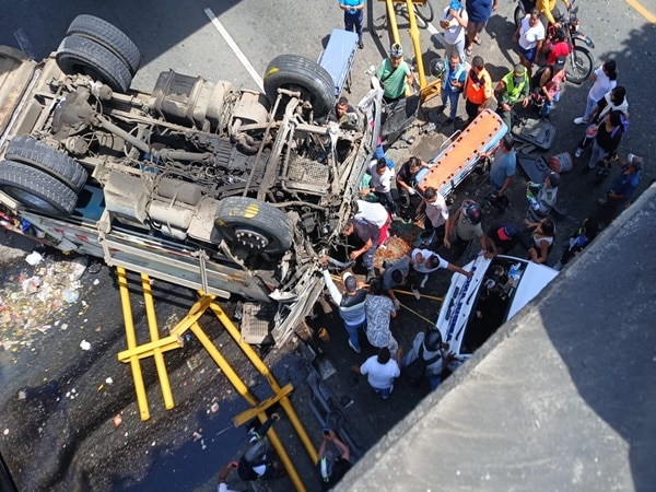 Personas que pasan por la zona intentan socorrer a las víctimas atrapadas entre las latas retorcidas del vehículo recolector