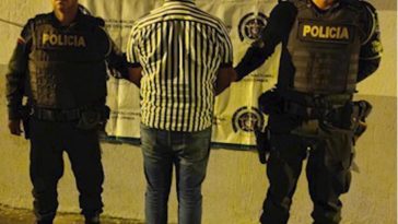 En la imagen se ve una persona detenida de espaldas, bajo custodia de la Policía Nacional.