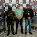 El capturado es visto junto a un uniformado del Ejército Nacional y un investigador del CTI.  Detrás de ellos las pancartas que identifican al Ejército Nacional.