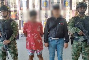 En la fotografía aparece una mujer capturada, acompañada de un servidor del CTI y de uniformados del  Ejército  Nacional.  En la parte posterior un banner con logos de la entidad.