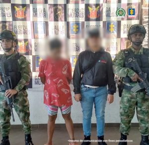 En la fotografía aparece una mujer capturada, acompañada de un servidor del CTI y de uniformados del  Ejército  Nacional.  En la parte posterior un banner con logos de la entidad.