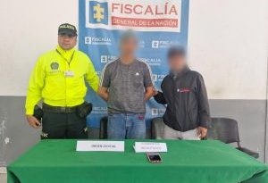 En la imagen aparece el denenido con una camiseta gris acompañado de un funcionario de la Policía y un funcionario del CTI