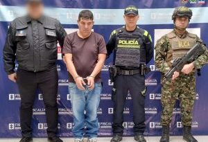 En la fotografía aparece el capturado junto a un servidor del CTI, un agente de Policía y un soldado del Ejército. En la parte superior está un banner de la Fiscalía General