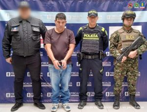 En la fotografía aparece el capturado junto a un servidor del CTI, un agente de Policía y un soldado del Ejército. En la parte superior está un banner de la Fiscalía General