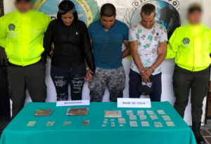 Se observa a los capturados junto a uniformados de la Policía Nacional. Frente a ellos una mesa con las sustancias alucinógenas incautadas. Detrás el banner que identifica a la Policía Nacional