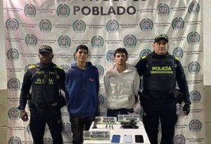 En la imagen están los 2 hombres asegurados con servidores de la Policía Nacional a los lados