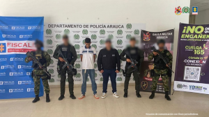 Se visualiza capturado junto a un investigador del CTI y uniformados del Gaula Militar y de Policía. Detrás de ellos los banners que identifican a la Fiscalía, Ejército y Policía Nacional.