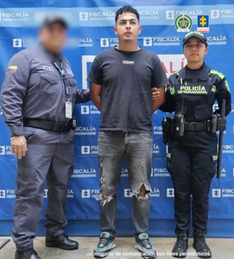 En la fotografía aparece de pie y con los brazos atrás Julio Alejandro Benavídez Martínez. Viste camiseta de manga corta de color gris oscuro, jean de color gris y zapatillas azules. Al lado derecho de él hay un servidor del CTI de la Fiscalía y a su izquierda una uniformada de la Policía Nacional. Detrás de ellos hay un pendón institucional de la Fiscalía.