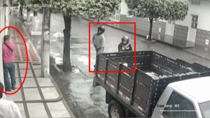 En la imagen se ve a dos hombres tras una camioneta.