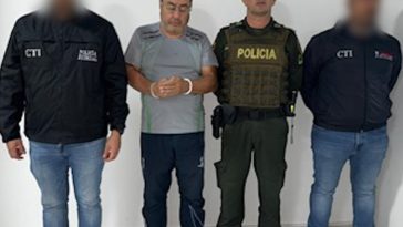 En la imagen se ve una persona detenida bajo custodia de dos integrantes del CTI y uno de la Policía.