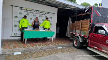 l capturado se encuentra en custodia por dos uniformados del Gaula de la Policía Nacional. En la foto se observa una mesa con la munición incautada.