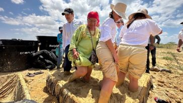 Un grupo de los funcionarios de las empresas aportantes del proyecto, junto con una wayuu, metidos dentro de un lodo, jugando para recibir energías positivas