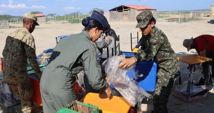 Instantes cuando soldados bajan del vehículo los pupitres que hicieron entrega para beneficiar a estudiantes de Maicao y Uribia.