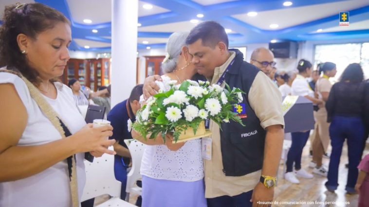 En la fotografía aparecen funcionarios de la Fiscalía y familiares de víctimas al interior de un salón recibiendo los restos de sus seres queridos.