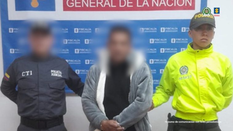 En la fotografía el acusado aparece de pie. Viste una chaqueta gris y blanca, una camiseta negra; Vaqueros azul oscuro y zapatillas blancas y negras. A su lado derecho se encuentra un servidor del CTI del Ministerio Público y a su lado izquierdo un uniformado de la Policía Nacional. Detrás de ellos hay una pancarta institucional del Ministerio Público.