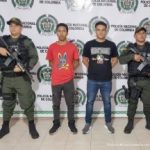 En la fotografía aparecen dos hombres capturados, acompañados de dos uniformados del Gaula de la Policía Nacional. En la parte posterior un banner con logos de la entidad.