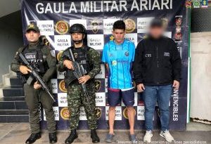 El capturado aparece junto a miembros del Ejército y del CTI, de pie, frente a un banner del Ejército.