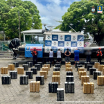 en la fotografía aparecen los cuatro imputados junto a dos infantes de la Armada Nacional. en la parte posterior está el cargamento de cocaína incautado