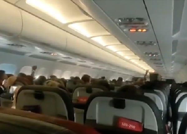 Pasajeros orando en un avión.