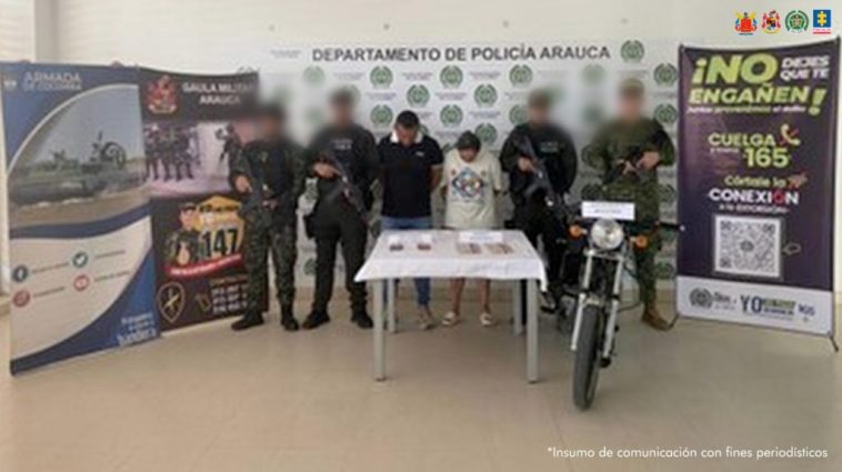 Se visualiza a los capturados junto a uniformados del Gaula Militar, Policía y Armada Nacional. Frente a ellos el dinero obtenido de la extorsión. Detrás de ellos los banners institucionales de la Policía, Armada y Ejército Nacional