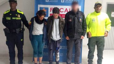 En la fotografía aparecen los capturados junto a un servidor del CTI y dos uniformados de la Policía Nacional. En la parte superior está un banner de la Policía