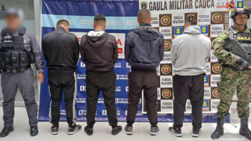 En la fotografía aparecen los cuatro capturados junto a un servidor del CTI y un soldado del Gaula Militar. En la parte superior está un banner de la Fiscalía General y otro banner del Gaula Militar.