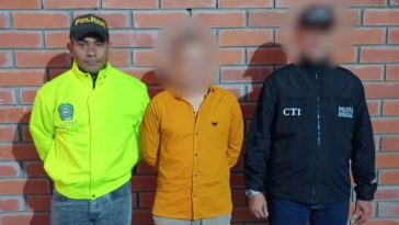 El capturado se encuentra de frente  y custodiado por un servidor del Cuerpo Técnico de Investigación CTI y un uniformado de la Policía Nacional