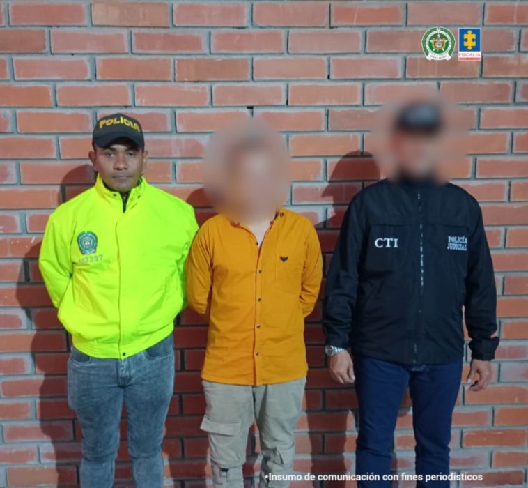 El capturado se encuentra de frente  y custodiado por un servidor del Cuerpo Técnico de Investigación CTI y un uniformado de la Policía Nacional